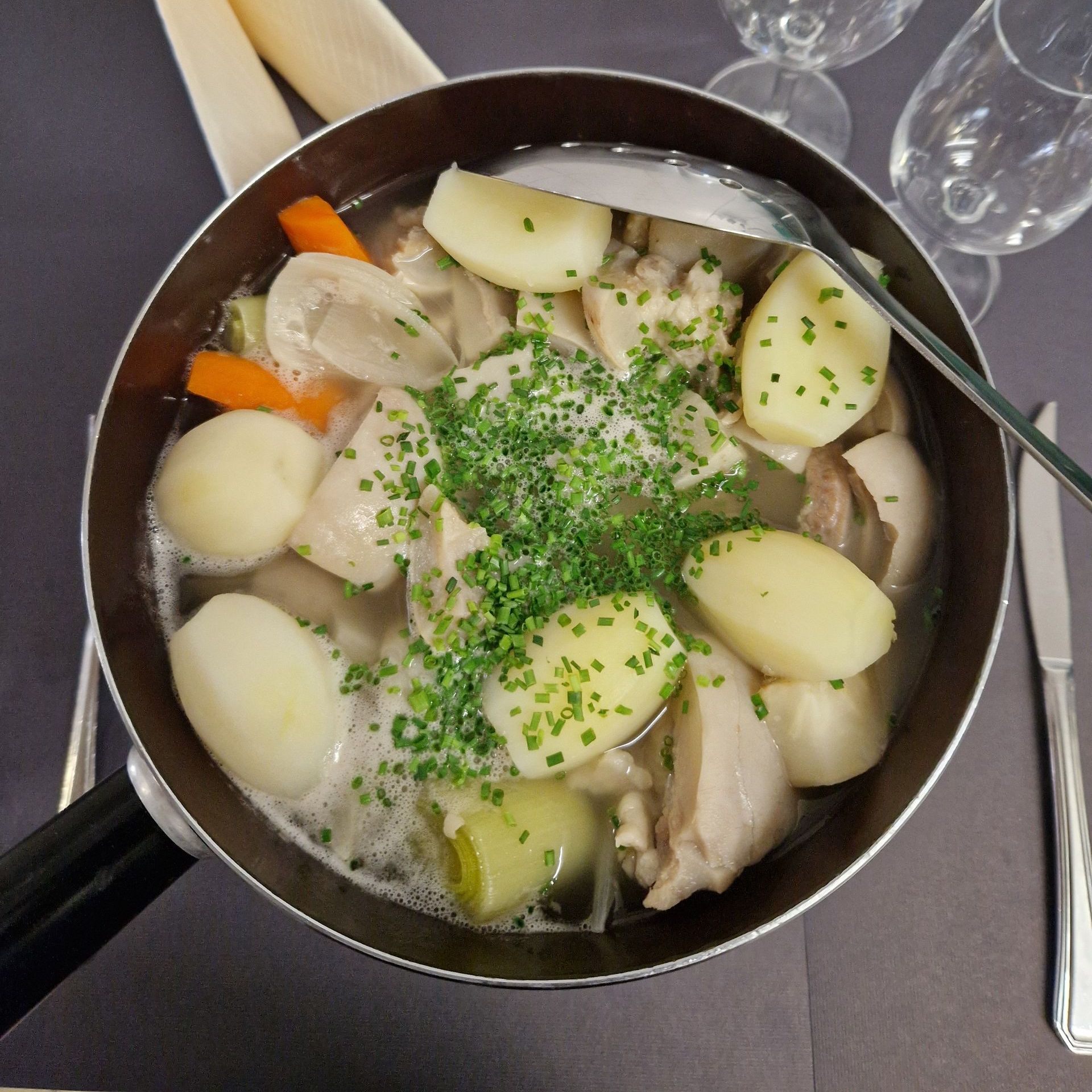Une poêle remplie de poulet, de pommes de terre et de carottes 