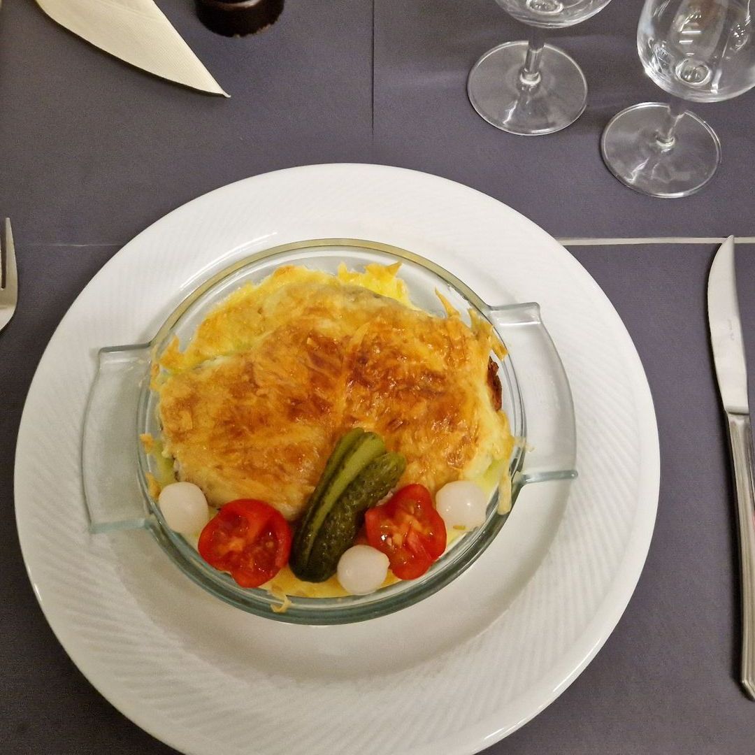 Une assiette de nourriture avec des tomates et des cornichons dessus