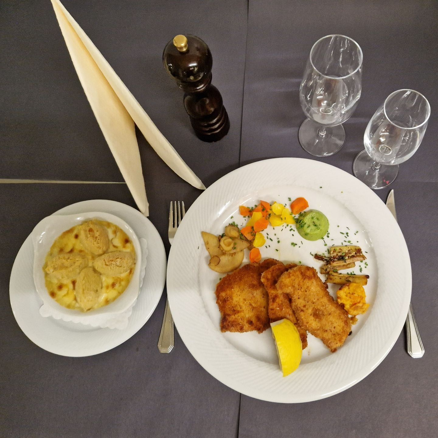 Une assiette de nourriture est posée sur une table à côté d'un gratin de pommes de terre