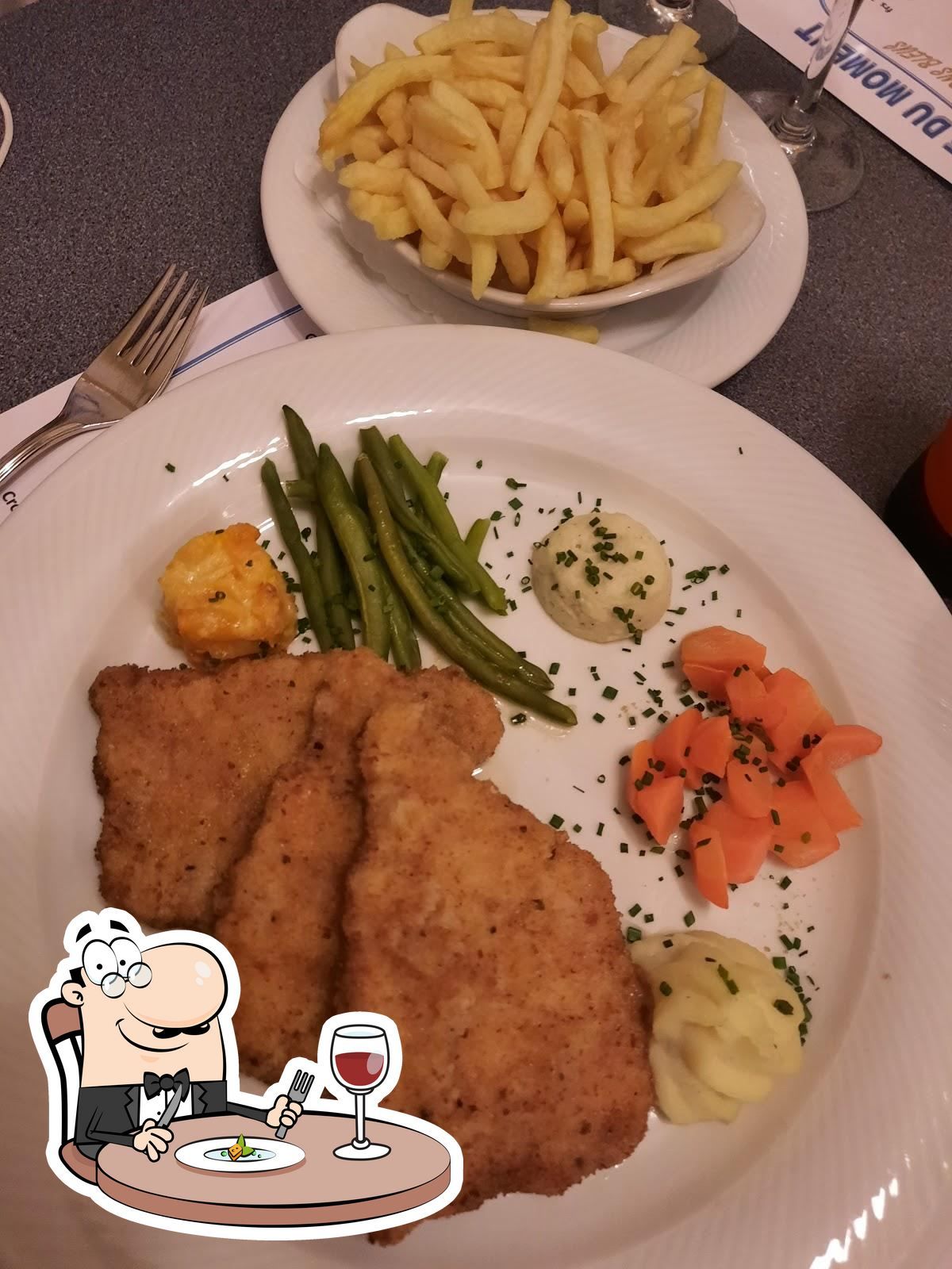 Une assiette de nourriture avec des carottes et des haricots verts sur une table