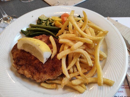 Une assiette de nourriture avec des frites et une tranche de citron