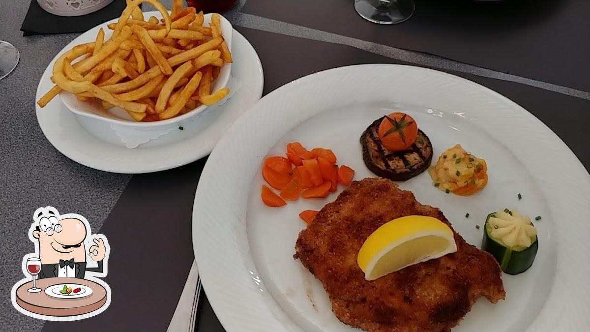 Une assiette de nourriture avec un bol de frites sur une table.