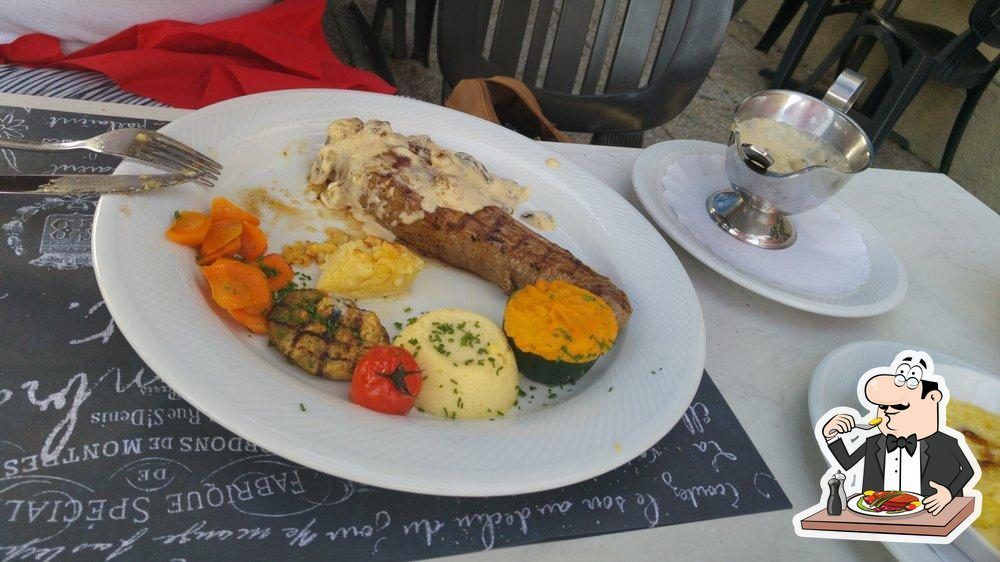 Une assiette de nourriture avec une saucisse et des légumes sur une table