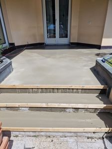 Personne appliquant un enduit protecteur sur un plancher en bois à l'aide d'un pinceau tout en portant des gants.