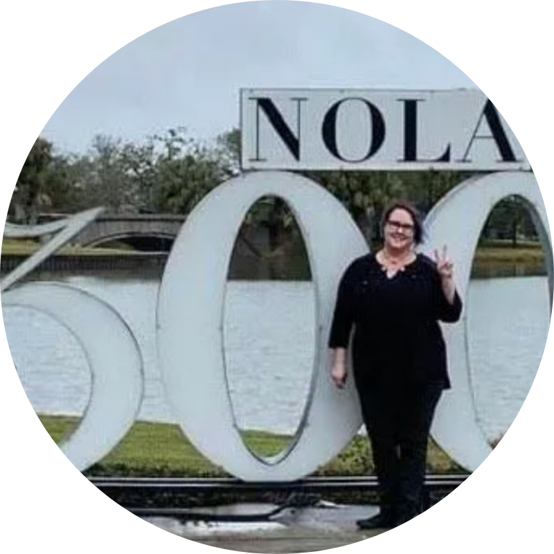 A woman is standing in front of a sign that says nola 500