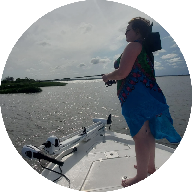 A woman is standing on the back of a boat holding a fishing rod.