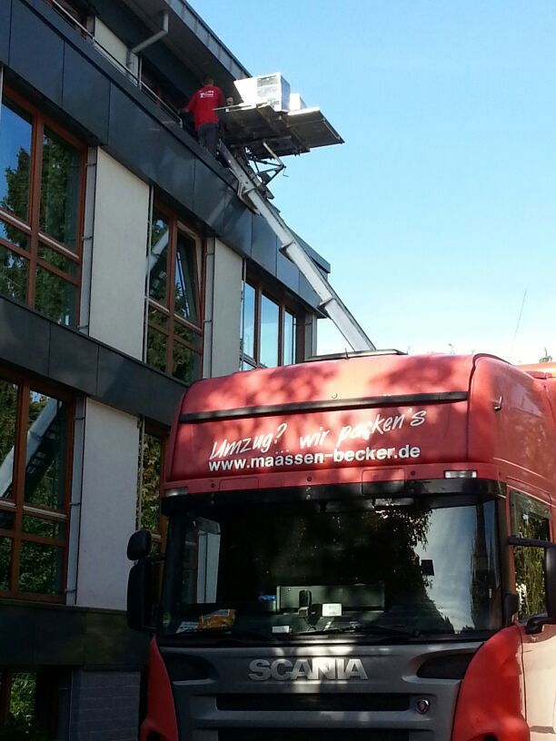 Ein roter Scania-Truck steht vor einem Gebäude