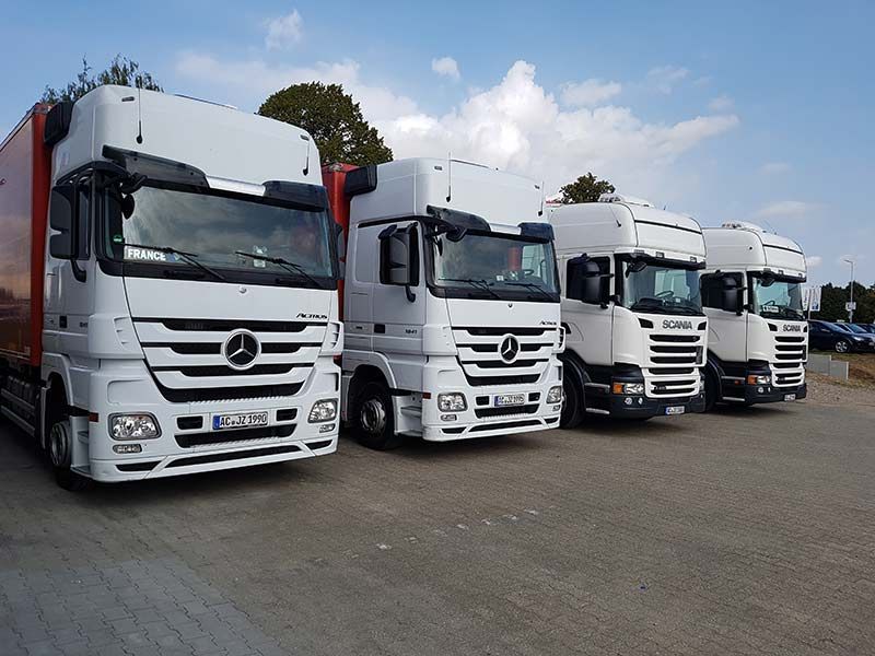 Eine Reihe von Mercedes-Lastwagen stehen auf einem Parkplatz
