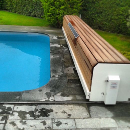 Piscine avec volet de sécurité en bois.