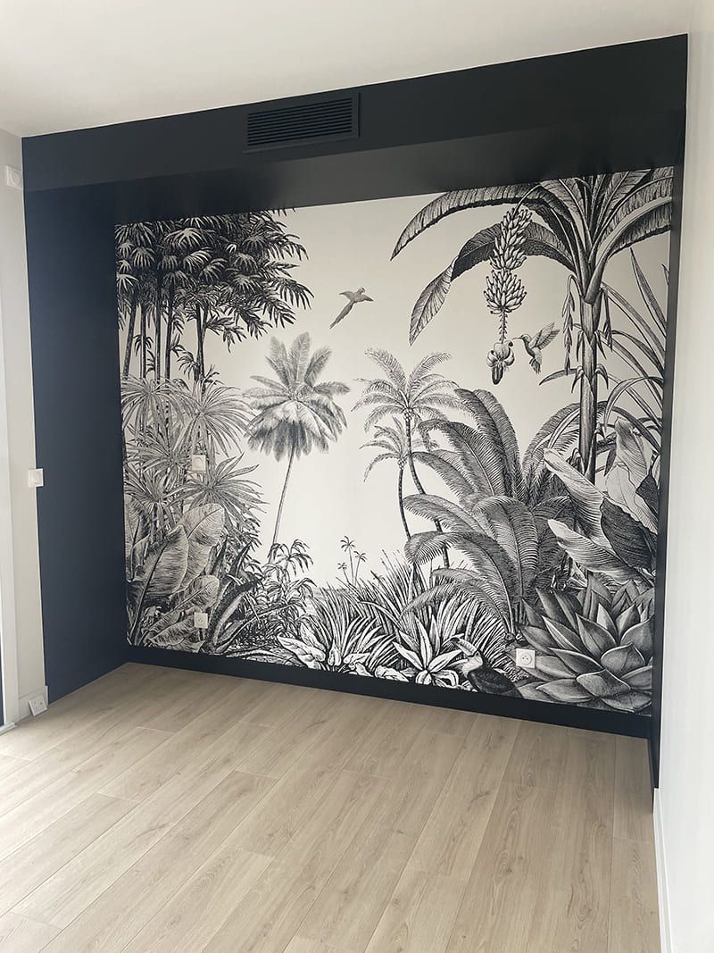 Une alcôve ornée d'un papier peint à motifs de jungle en noir et blanc, encadrée par une structure en bois sombre et encastrée et un parquet.