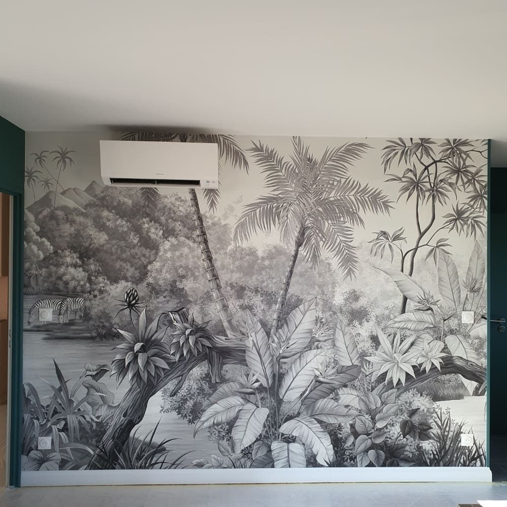 Un mur recouvert d'un papier peint monochrome noir et blanc à motif de jungle, représentant des palmiers, du feuillage et une rivière.