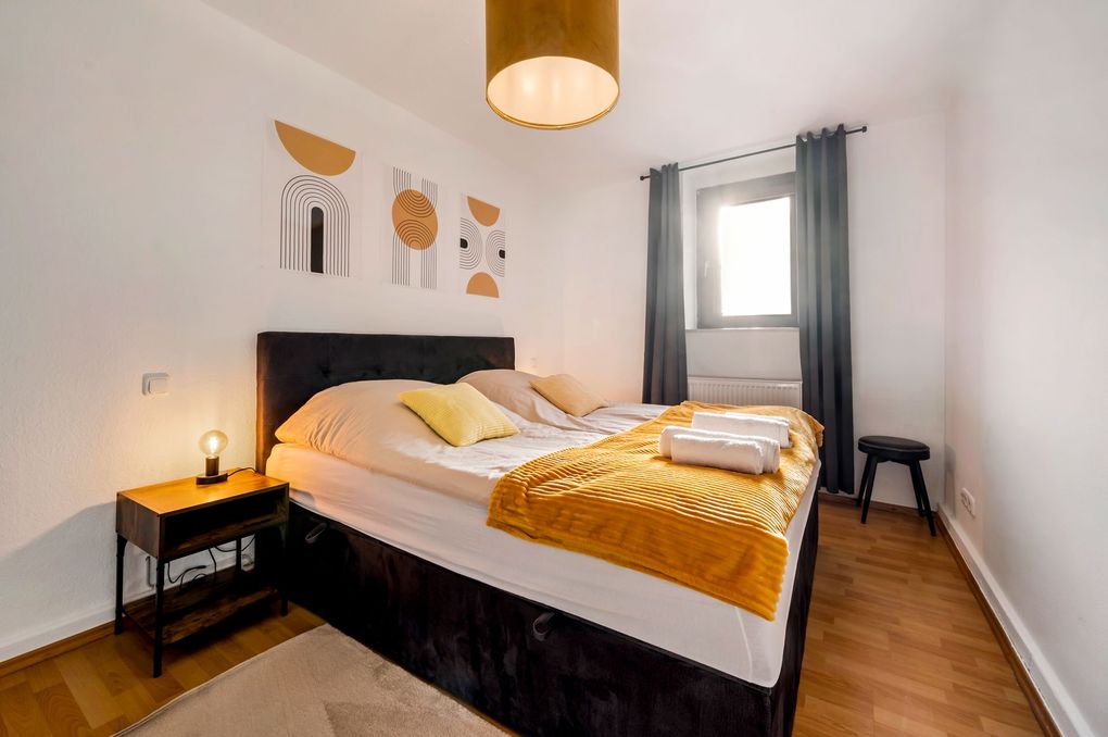 Komfortables Doppelbett in einem geschmackvoll eingerichteten Schlafzimmer mit warmem Licht und harmonischem Design.
