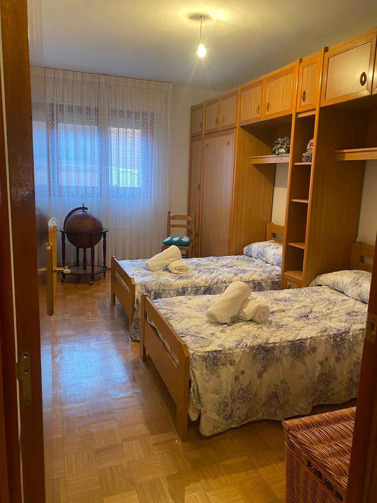 Un dormitorio con dos camas individuales con ropa de cama de estampado floral azul y blanco.