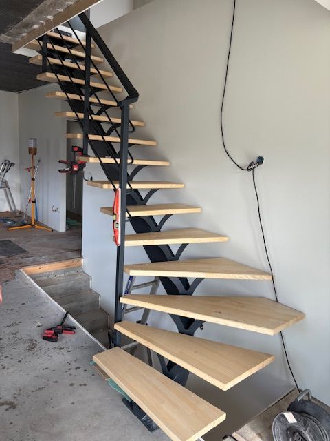 Escalier en colimaçon en bois ouvert en construction dans une pièce intérieure nue