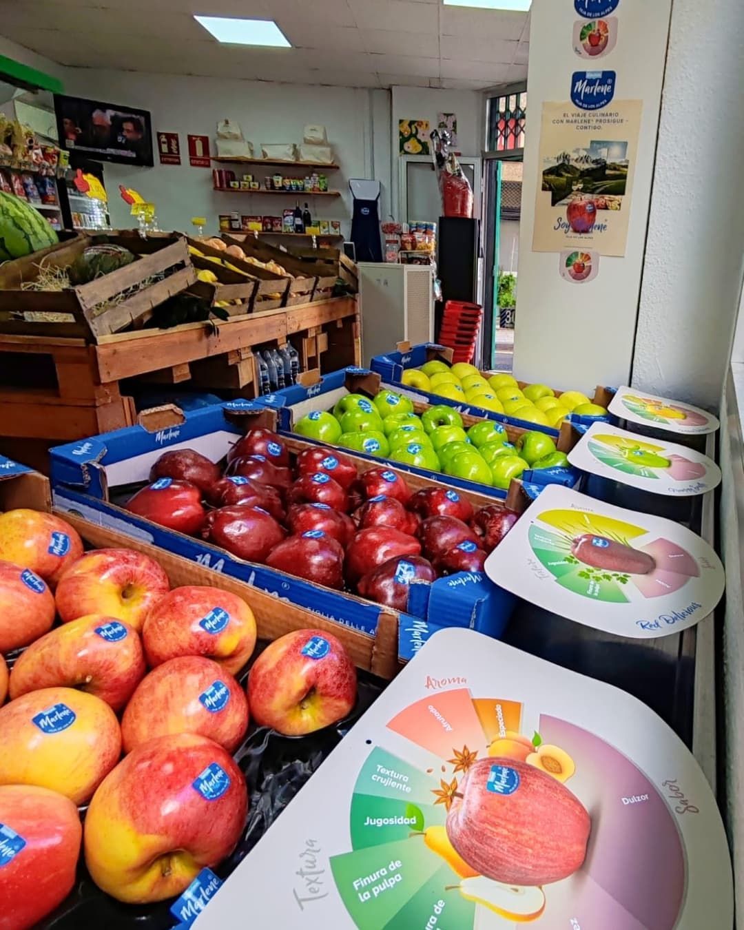Manzanas en cajas en un mercado. Se exhiben manzanas rojas, verdes y amarillas.