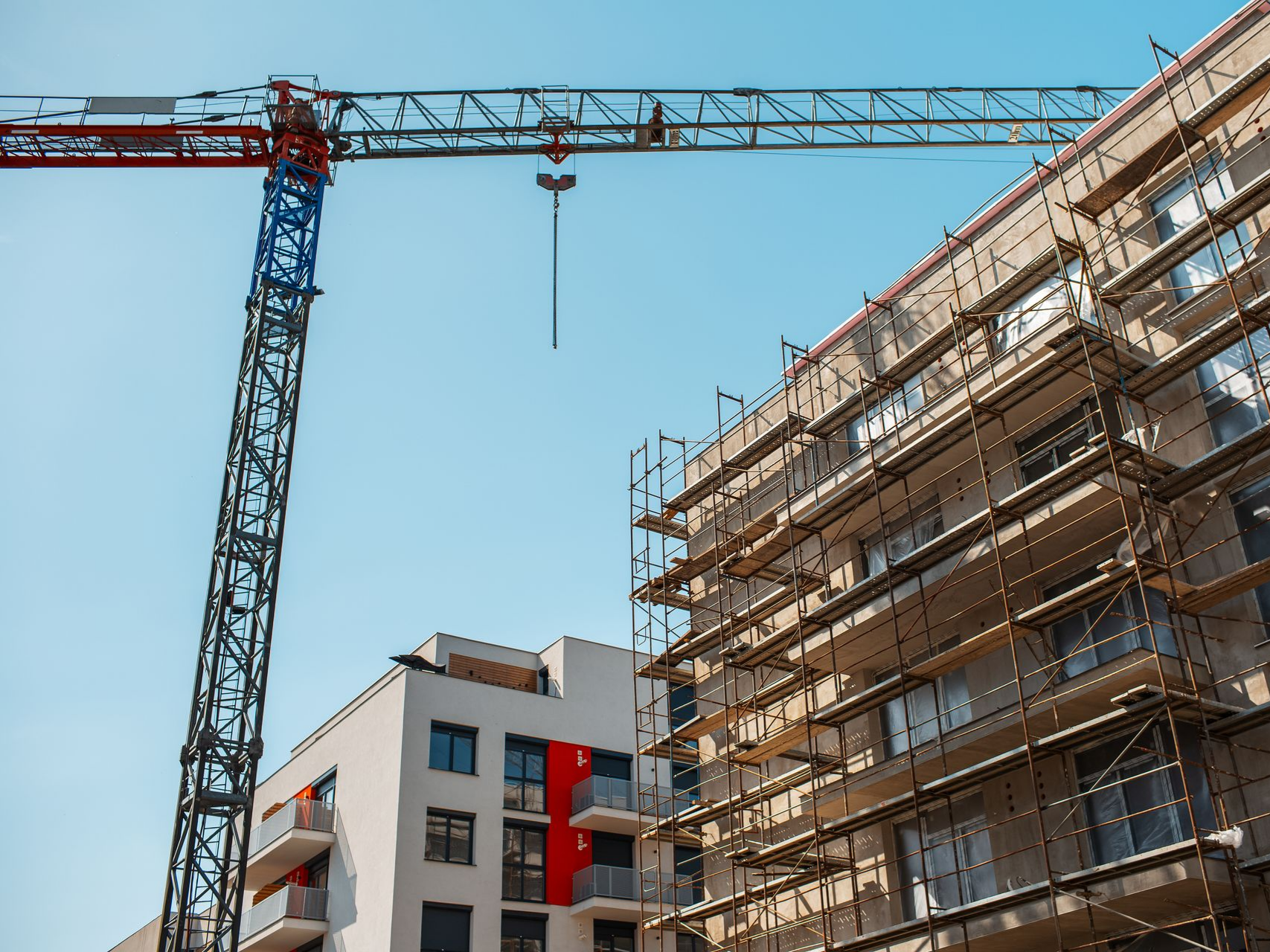 Chantier de construction avec grue et échafaudages sur un bâtiment.