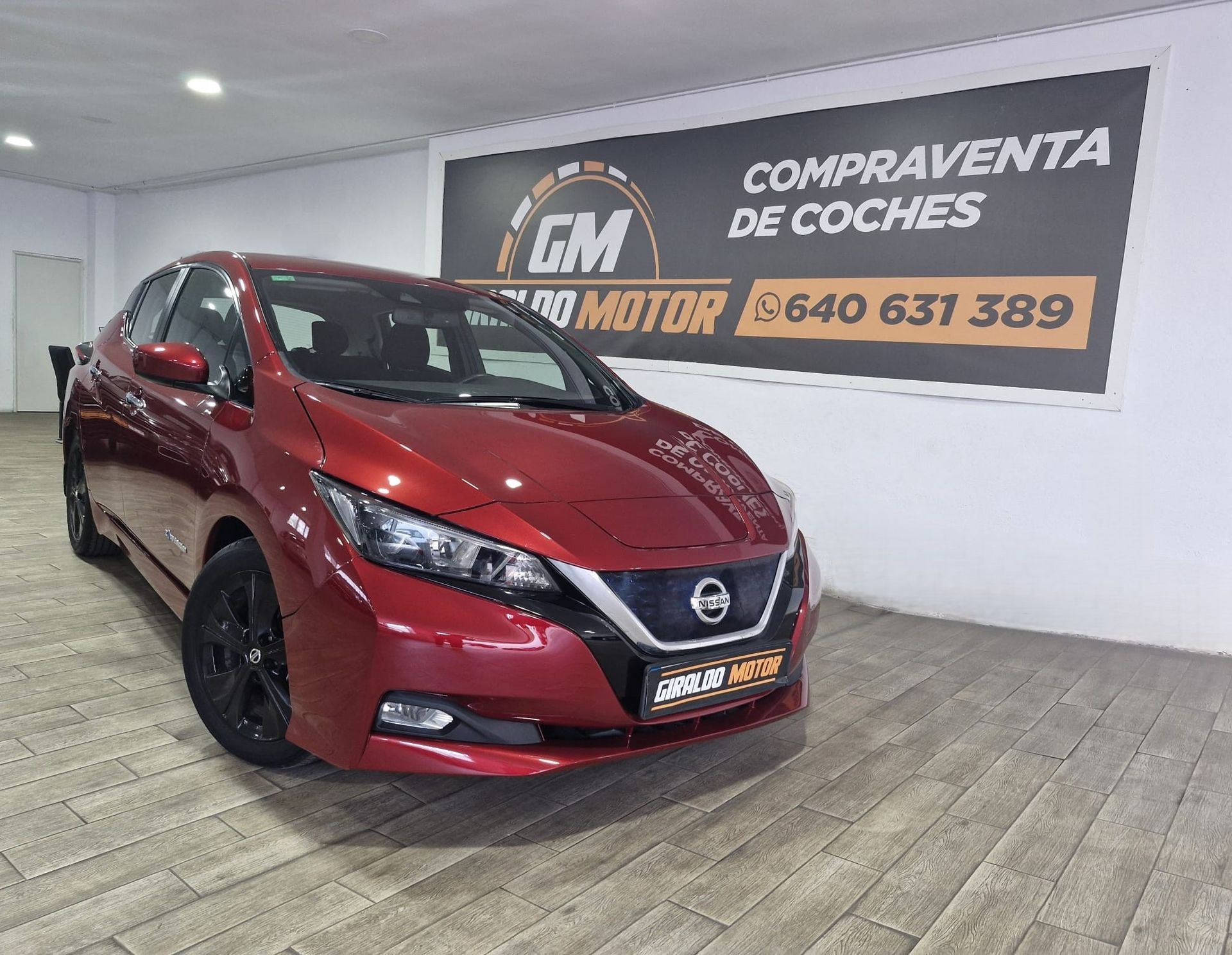 Coche eléctrico Nissan Leaf de color rojo en un concesionario.