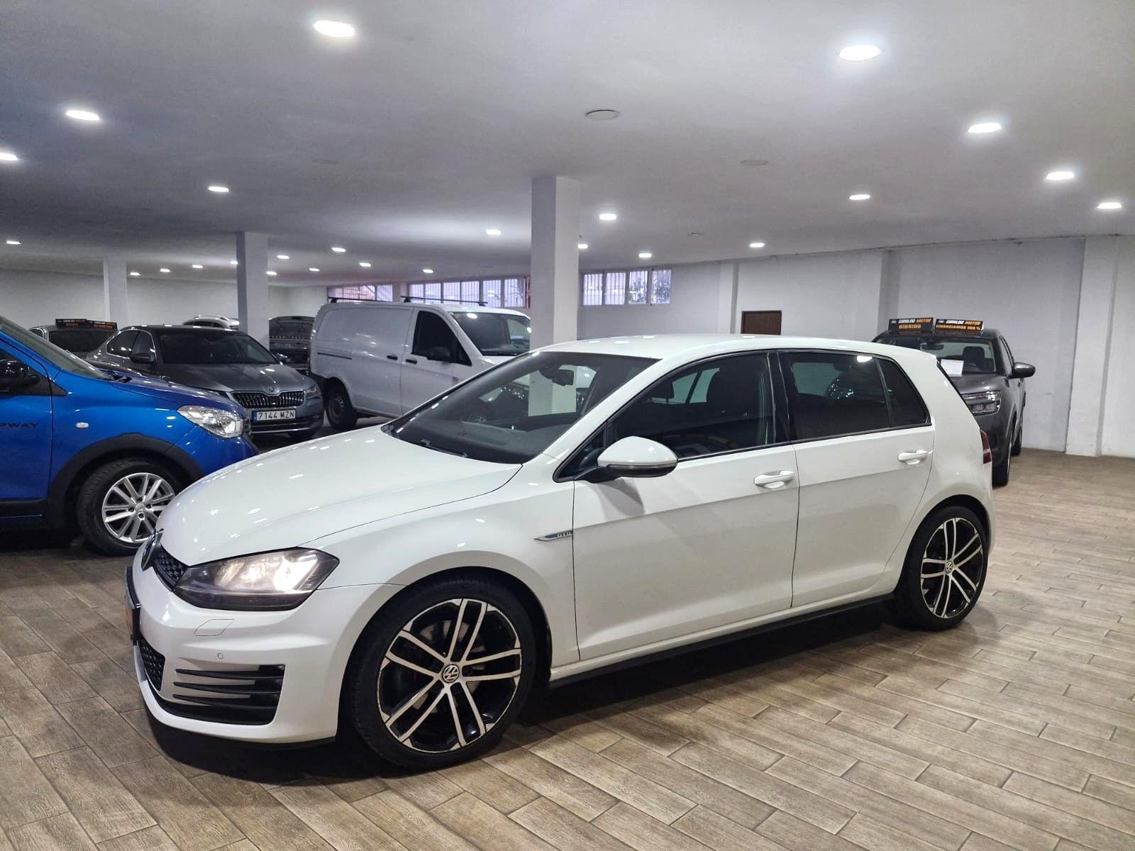 Un automóvil Renault Mégane de color azul en un concesionario; al fondo hay un cartel de Giraldo Motor.