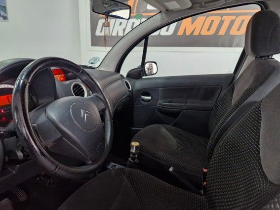 Un automóvil Renault Mégane de color azul en un concesionario; al fondo hay un cartel de Giraldo Motor.