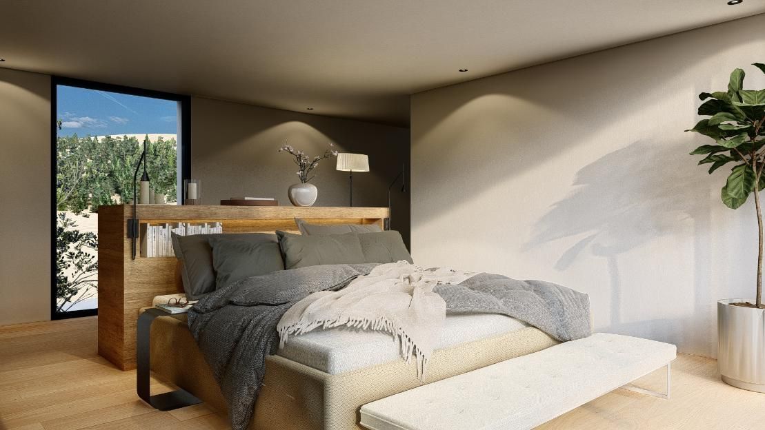 Interior de dormitorio con cama grande, banco y planta alta. Vista de árboles y cielo desde la ventana.