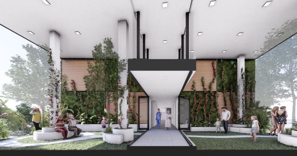 Entrada de un edificio moderno con elementos naturales y gente interactuando. Muros verdes, asientos y árboles visibles.