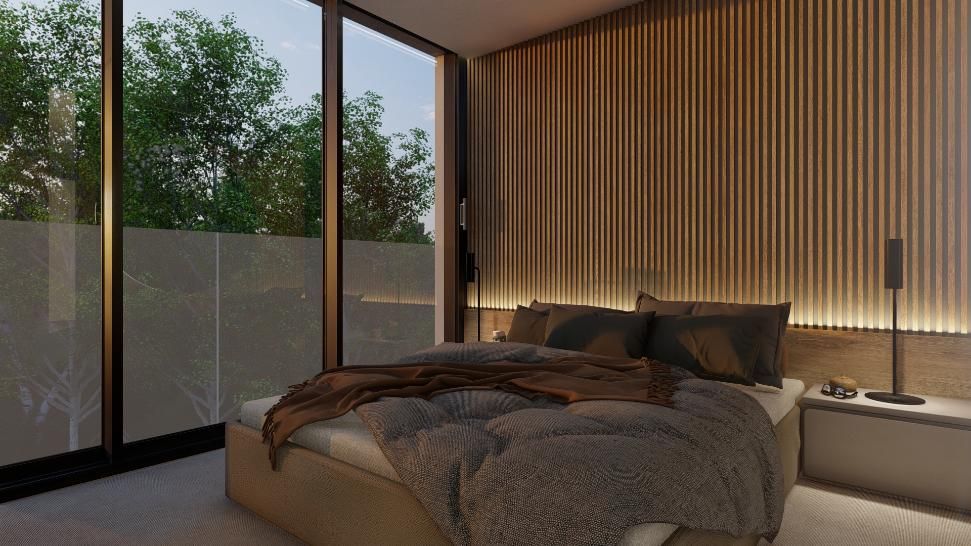 Interior de dormitorio con pared de paneles de madera, ventana grande y cómoda cama con ropa de cama de felpa.