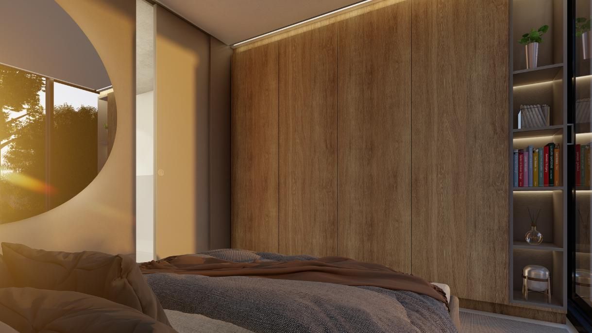 Dormitorio con paneles de madera, estantes empotrados, cama con manta marrón y gran espejo redondo.