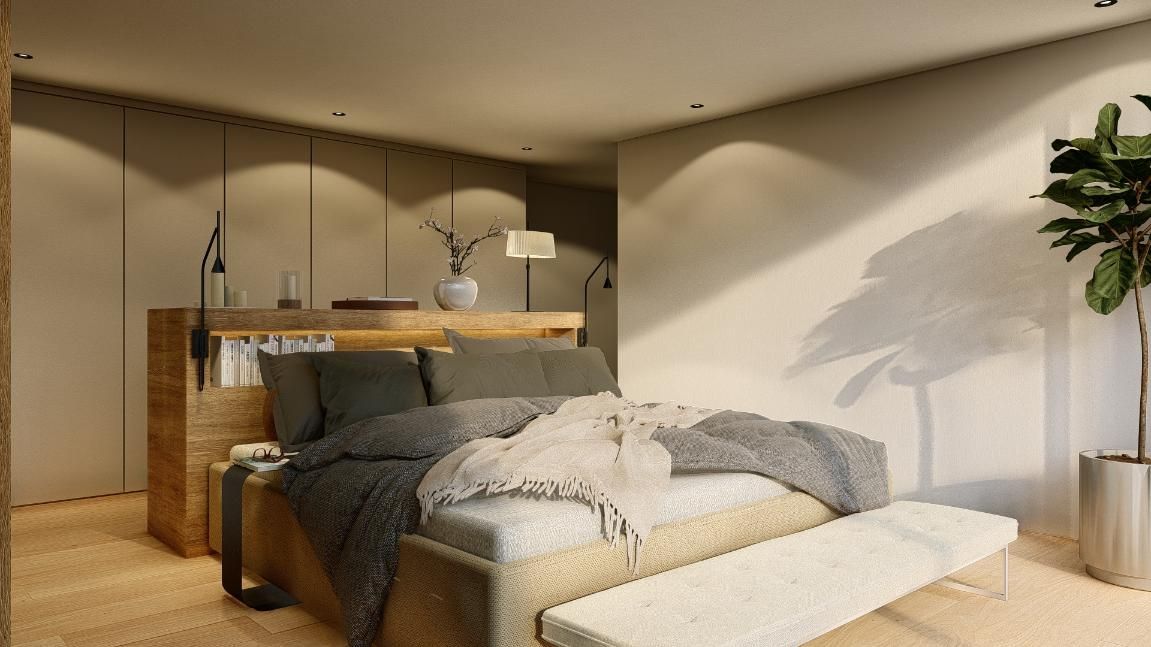 Dormitorio con cama, banco, mesa auxiliar, estantería empotrada, maceta y lámpara de pared.