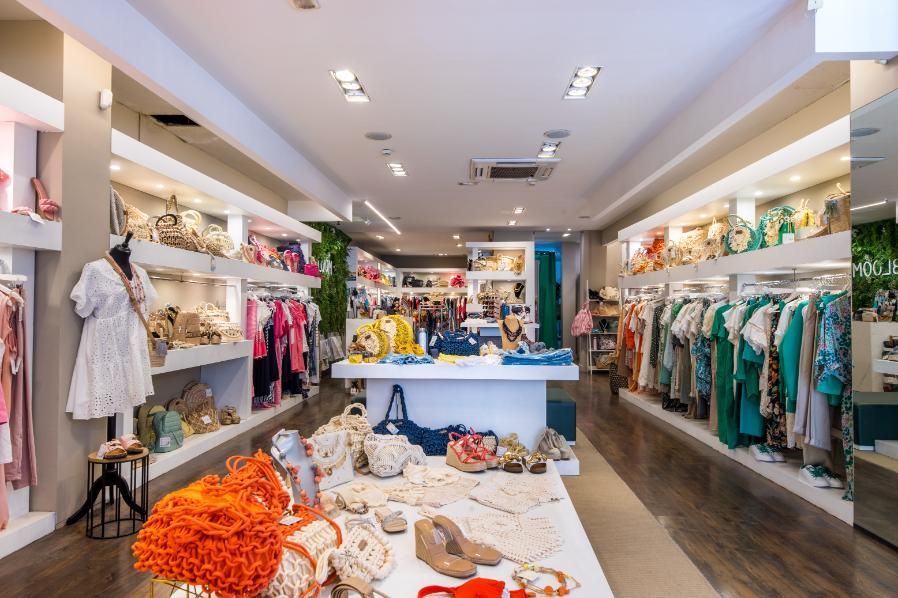 Interior de boutique de ropa con exhibidores de ropa y accesorios.