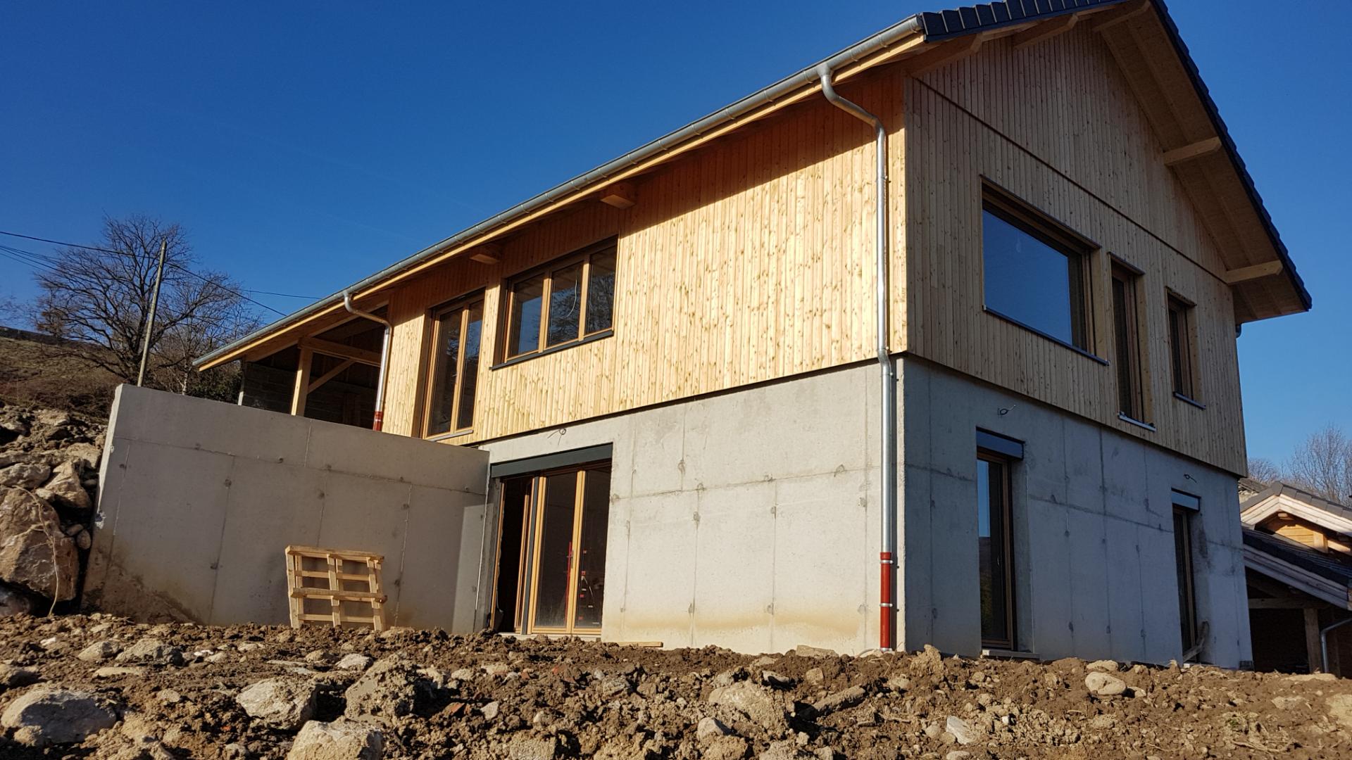 Maison en cours de construction avec le premier niveau en béton et l'étage réalisé en bois