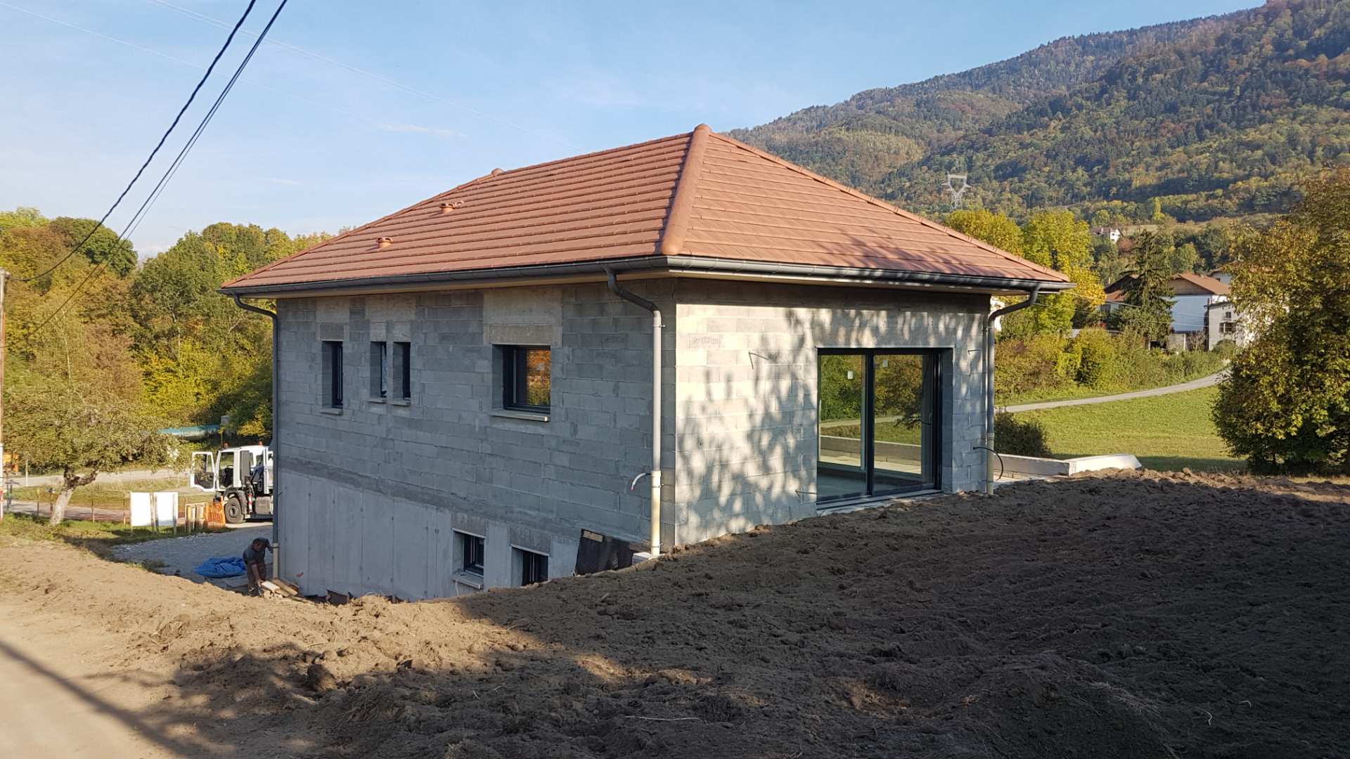 Pavillon avec dénivelé entre le rez-de-chaussée et le sous-sol à gauche en train d'être construit, sans peinture