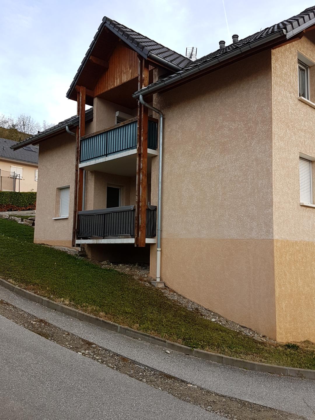 Logement collectif installé sur une pente proposant des balcons et une façade jaune et orange pales