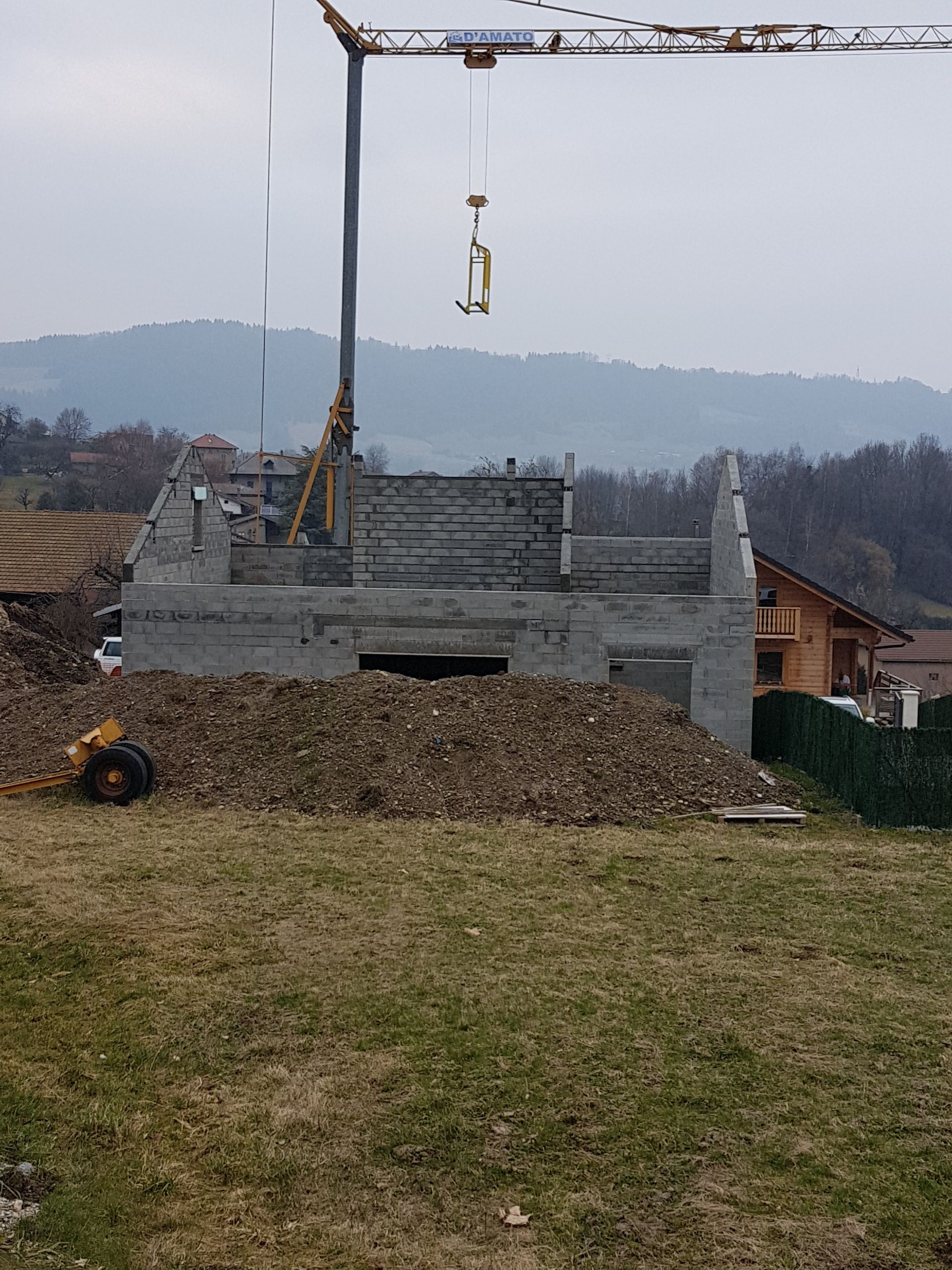 Vue de loin d'un chantier de construction d'une villa individuelle avec le bâtiment pour l'instant sans toit