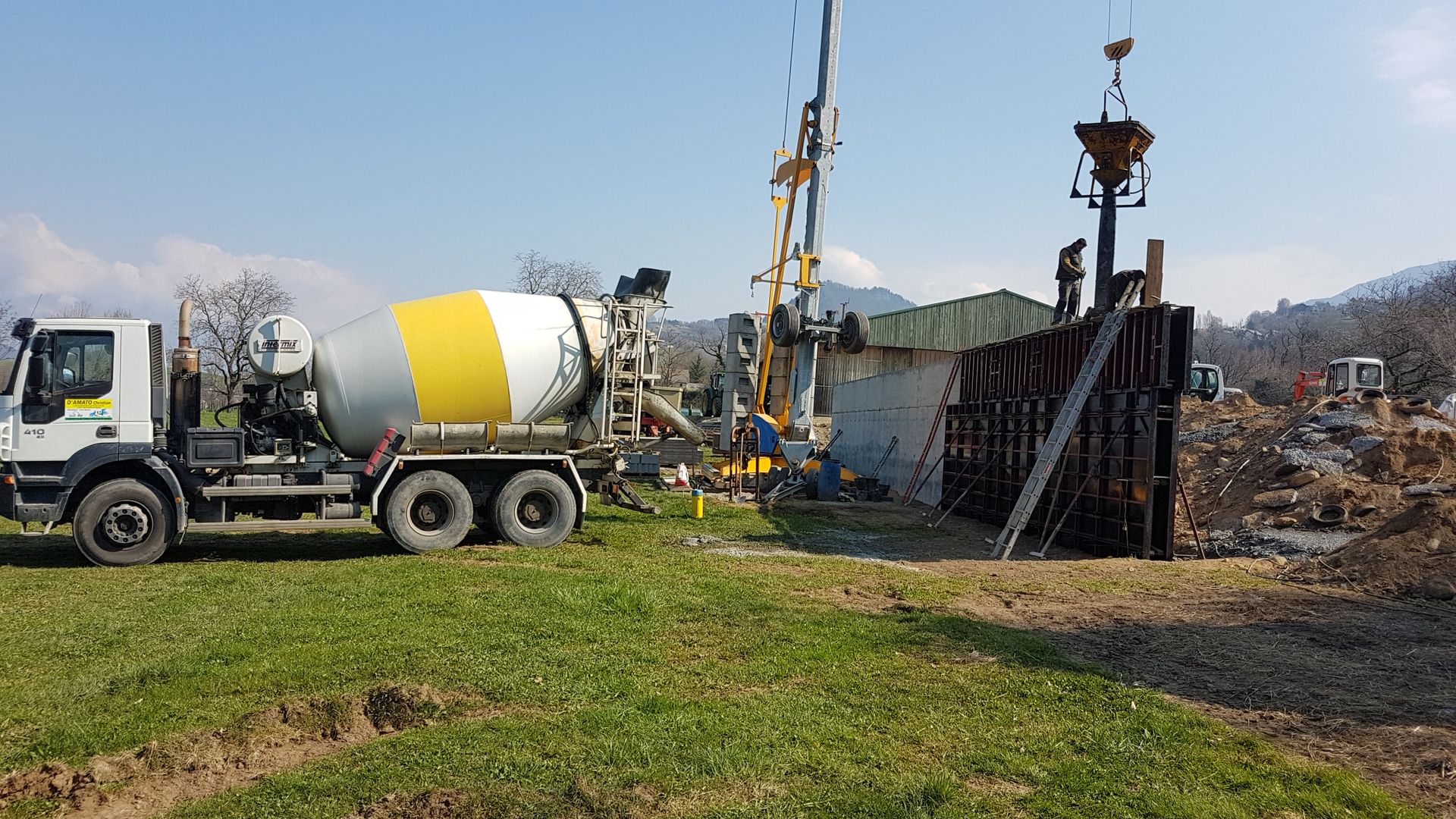 Bétonnière de profil à gauche garée pour la livraison d'un béton prêt à l'emploi, pour un chantier en cours