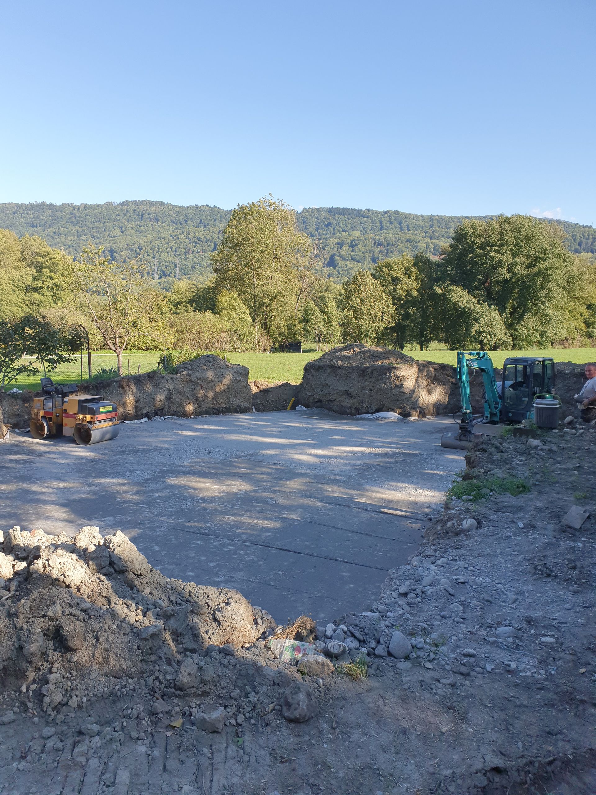 Terrassement en cours avec deux engins, à droite et à gauche, du terrain en cours d'aplanissement