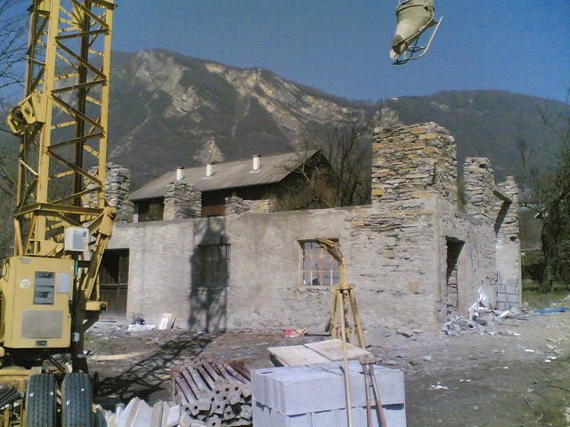 Grue en intervention pour la rénovation d'un bâtiment ancien en train de constituer les murs en béton