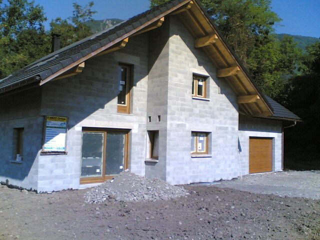 Maison individuelle en cours de construction proposant un garage à droite, mais sans la peinture murale extérieure