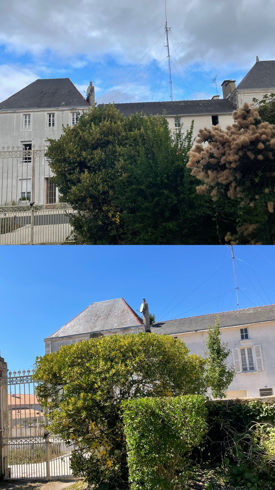 Maisons en pierre derrière des haies vertes sous un ciel bleu nuageux, photographiées en plein jour.