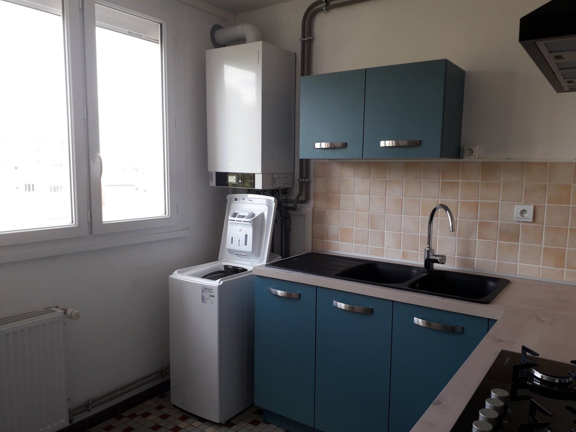 Partie évier dans une cuisine aux meubles bleus