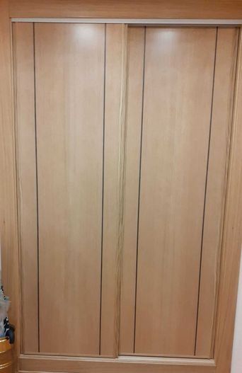 Puertas corredizas de armario de madera de color marrón claro.