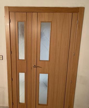Puertas dobles de madera con paneles de vidrio esmerilado.