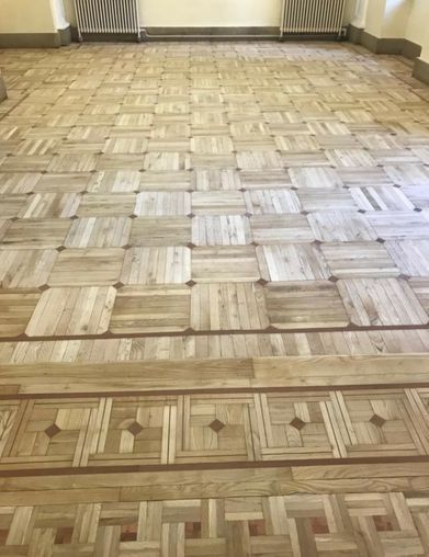Suelo de parquet de madera con cenefa decorativa.
