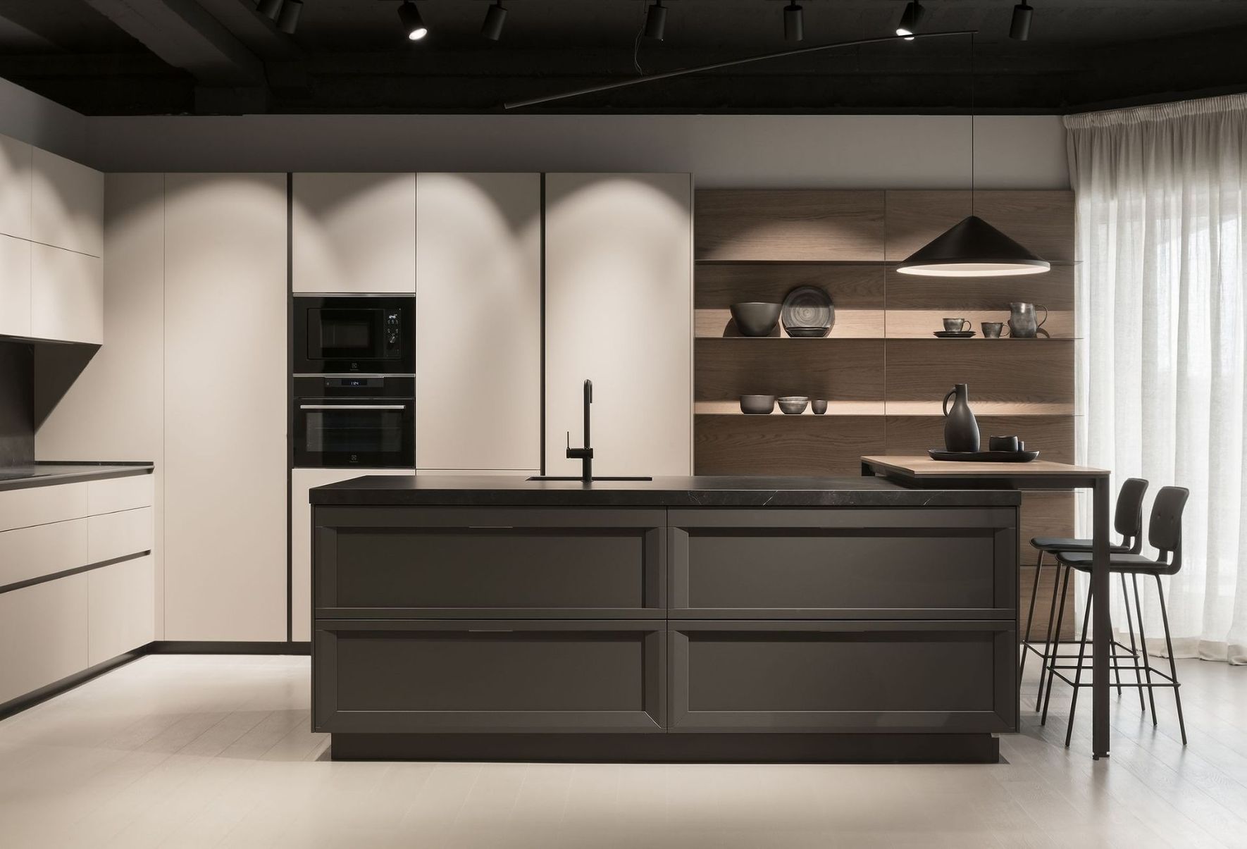 Cocina moderna minimalista con isla oscura, armarios claros, estantes de madera y taburetes de bar junto a una ventana luminosa.
