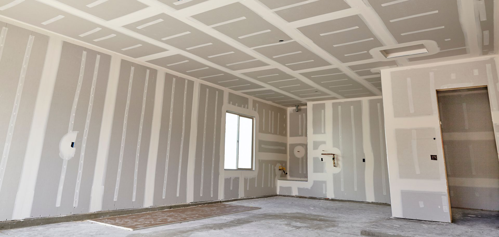 Intérieur de la pièce en cours de construction, murs et plafond en plaques de plâtre. Inachevé.