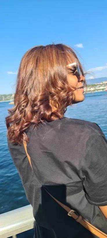 Une personne aux cheveux bouclés et portant des lunettes de soleil