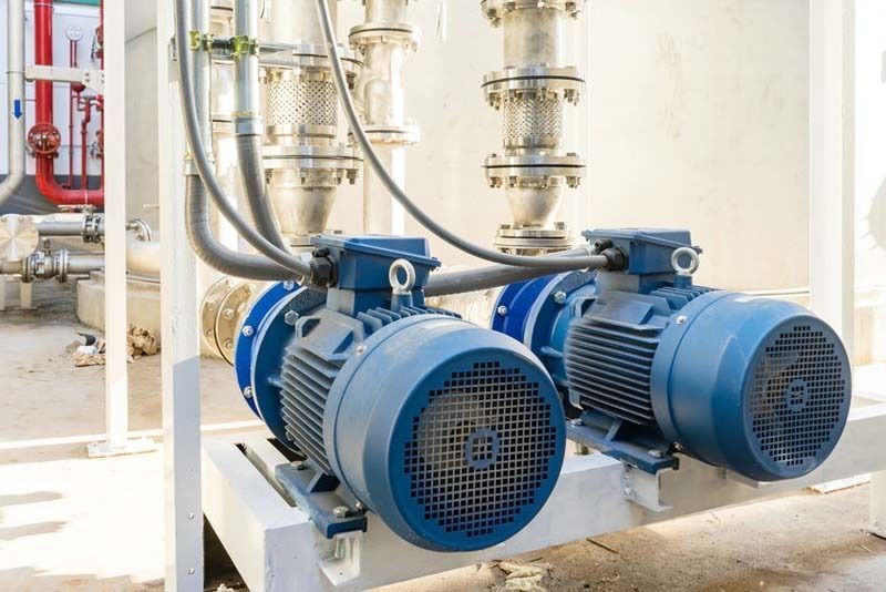 Dos motores eléctricos azules están sentados uno al lado del otro en una fábrica.