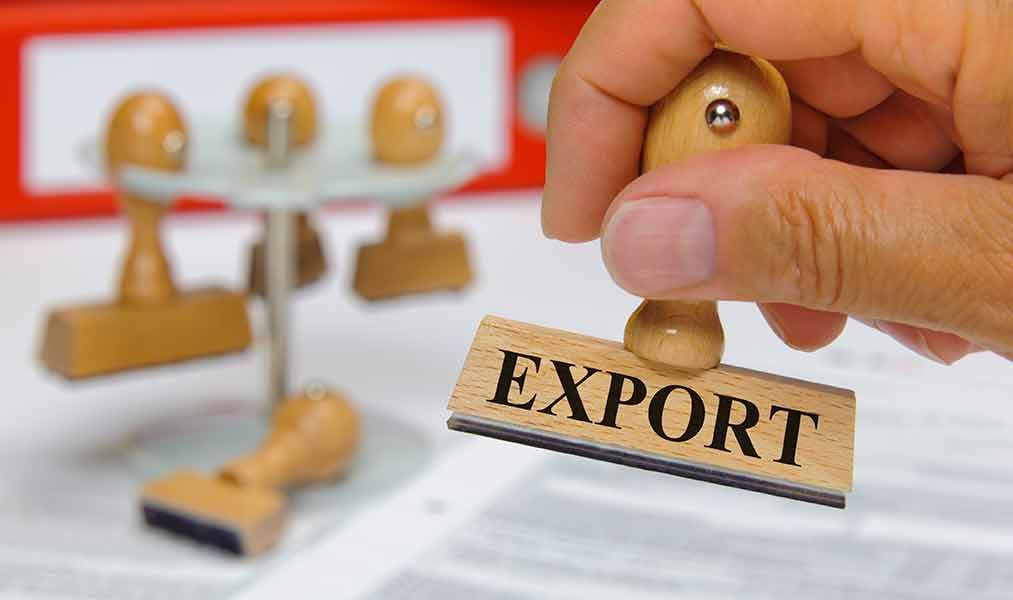 Eine Person hält einen Holzstempel mit der Aufschrift „Export“.