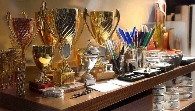 Ein Regal voller Trophäen und Stifte auf einem Tisch.