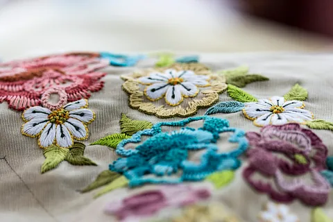 Un primer plano de un trozo de tela con flores bordadas.