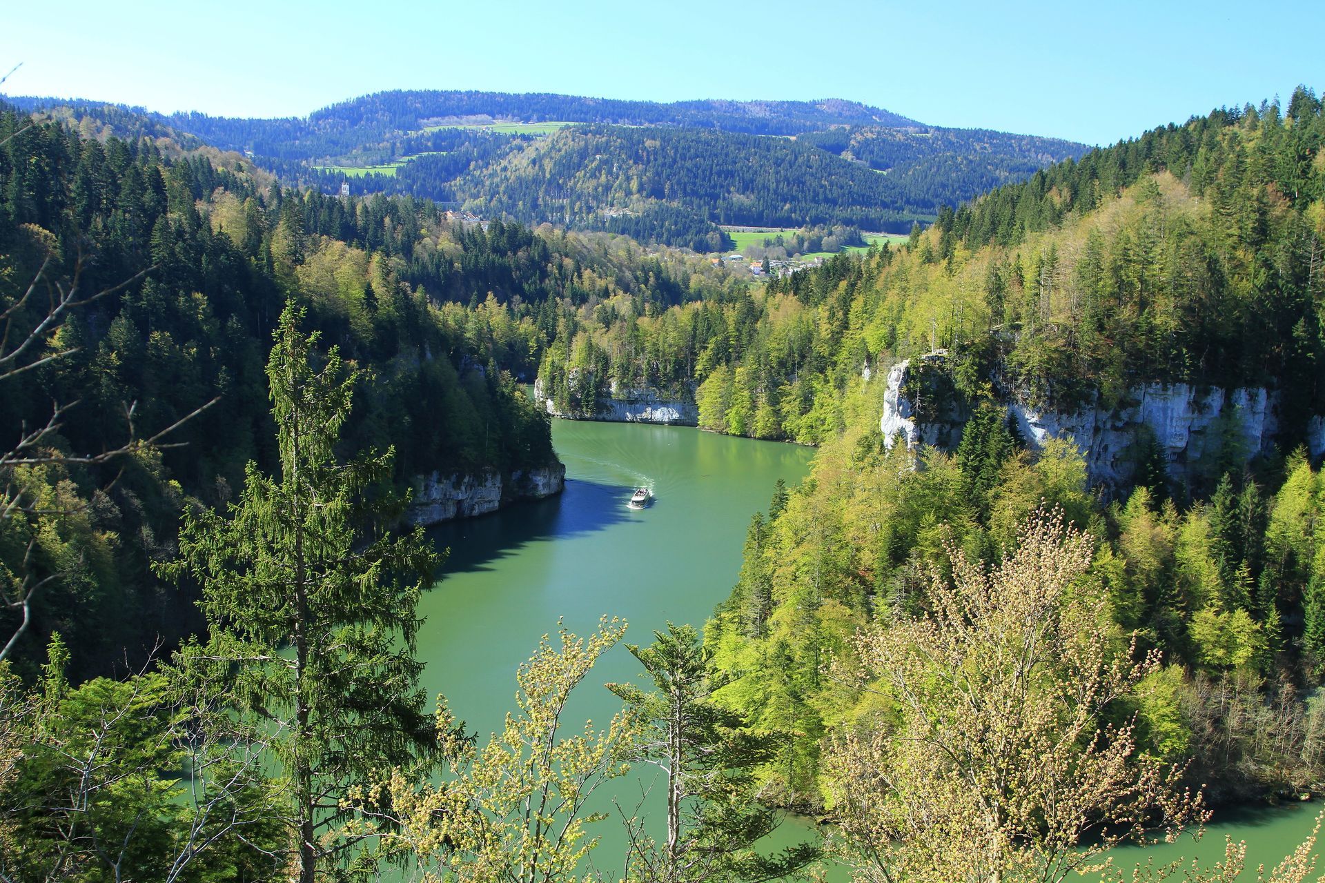 Paysage avec un fleuve qui sépare des rochers et montagnes en arrière-plan